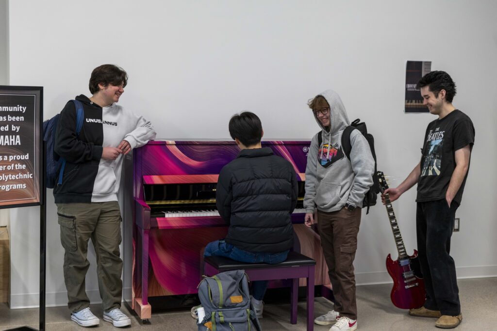 A group of students playing piano at the Humber Lakeshore campus.