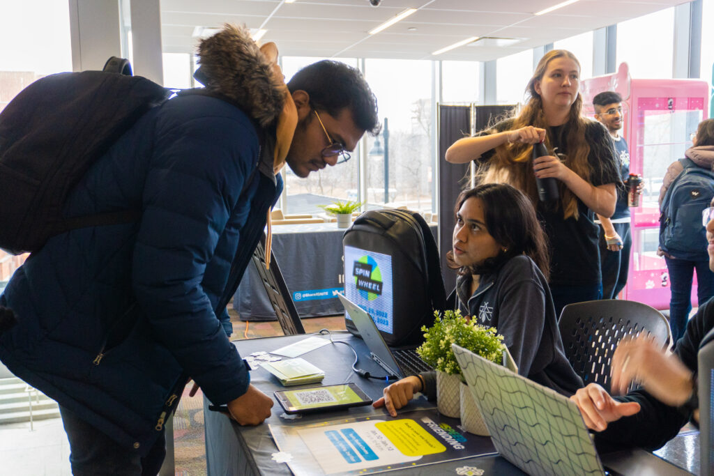 An IGNITE Employee assisting a student and directing them to information. 