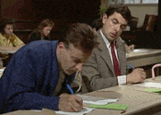 A man copying the answers of another man during an exam