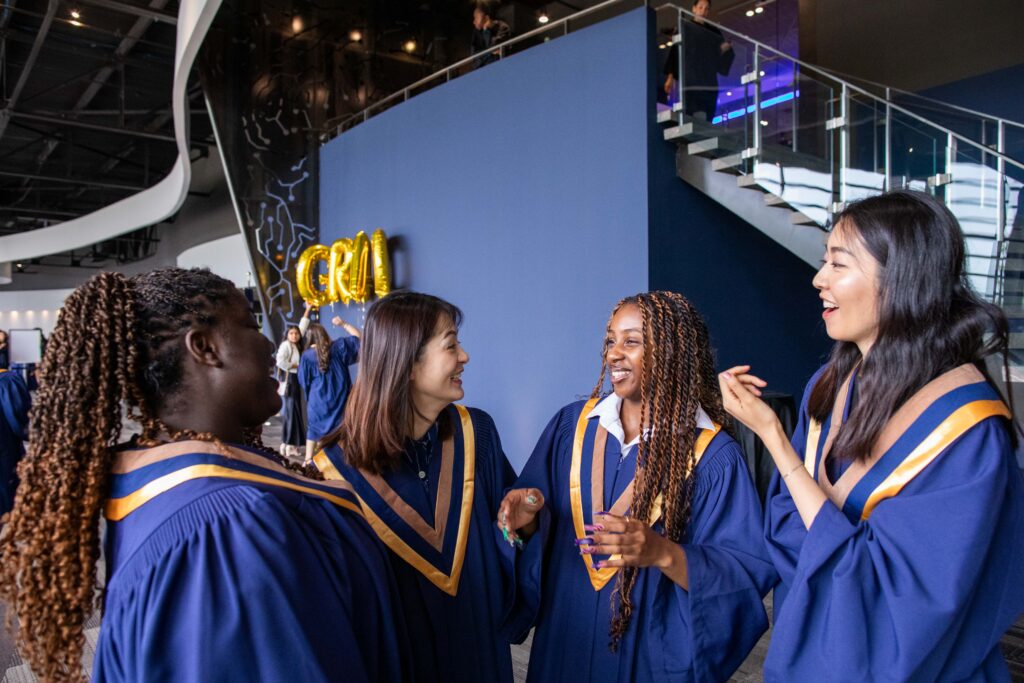 Three women are walking together in their graduation gowns.