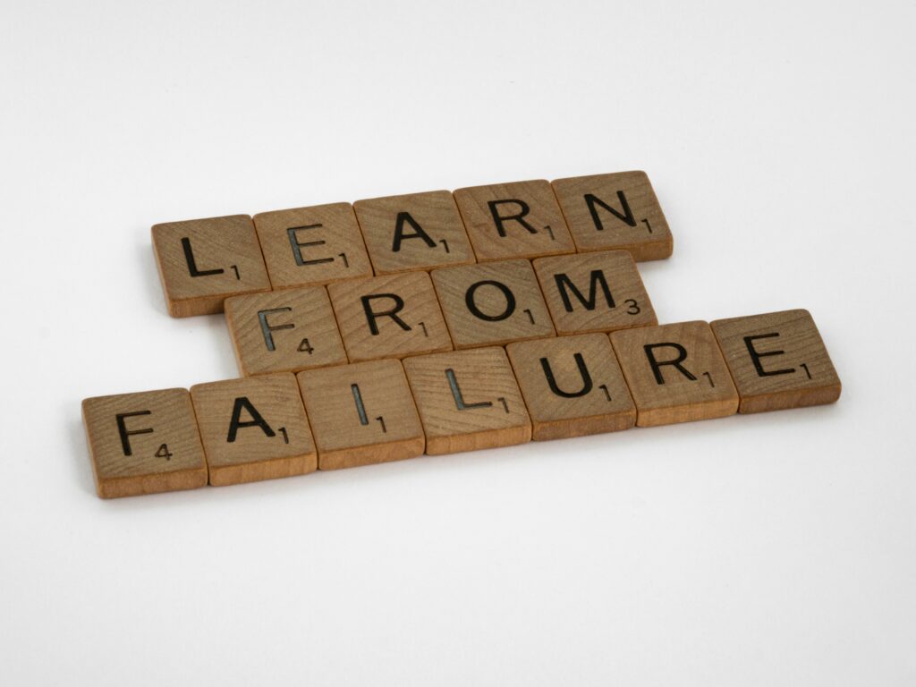 Scrabble blocks forming a sentence reading, "Learn from failure"