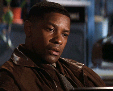 Denzel Washington putting his hands on his chest breathing heavily and smiling. 