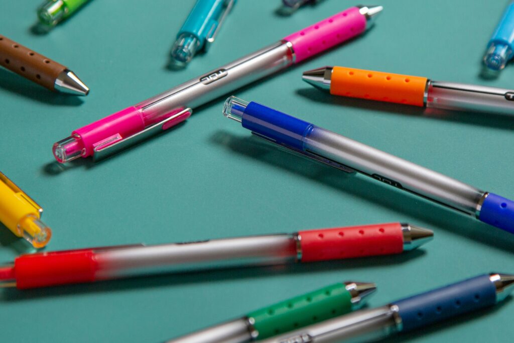 Various colored pens spread on a blue background