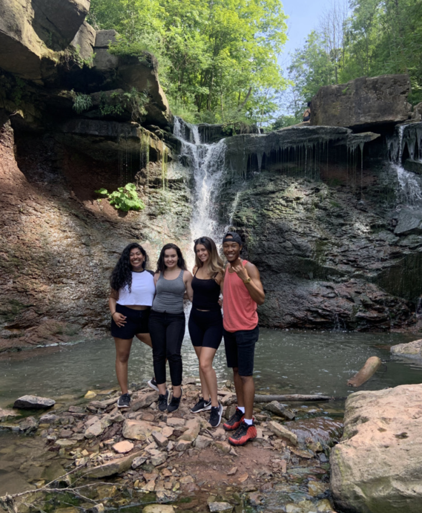 Julia Ciampa posing for a photo with her friends in front of a waterfall