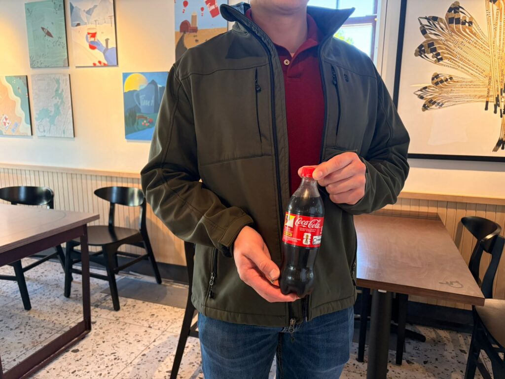 Photo of Christopher Sanchez Aguilera holding a bottle of Coca-Cola