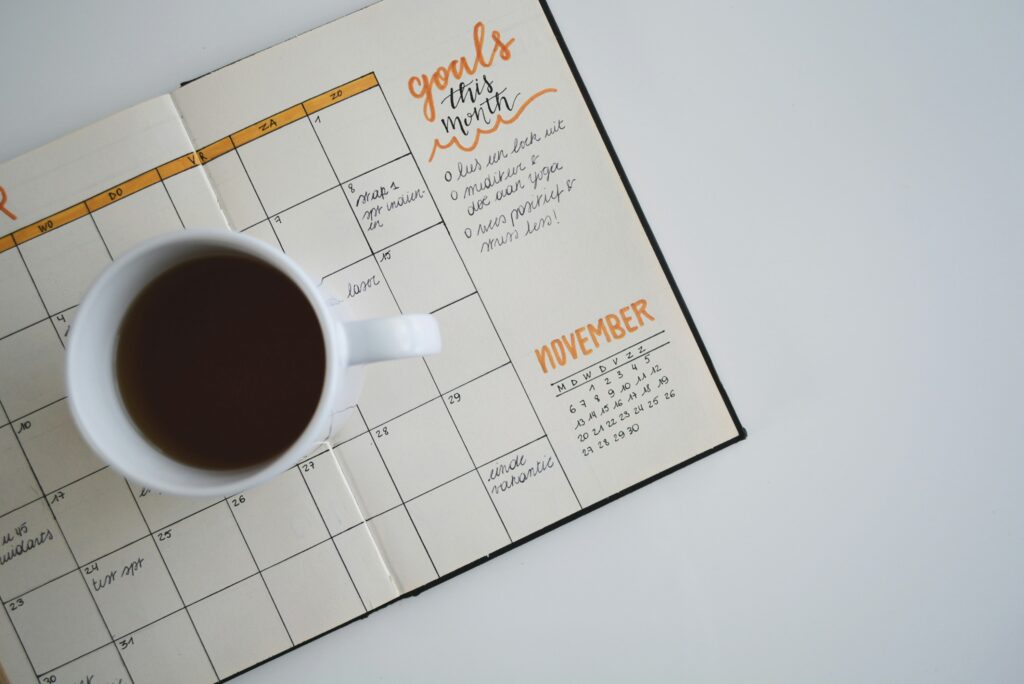 A coffee mug on top of an agenda notebook