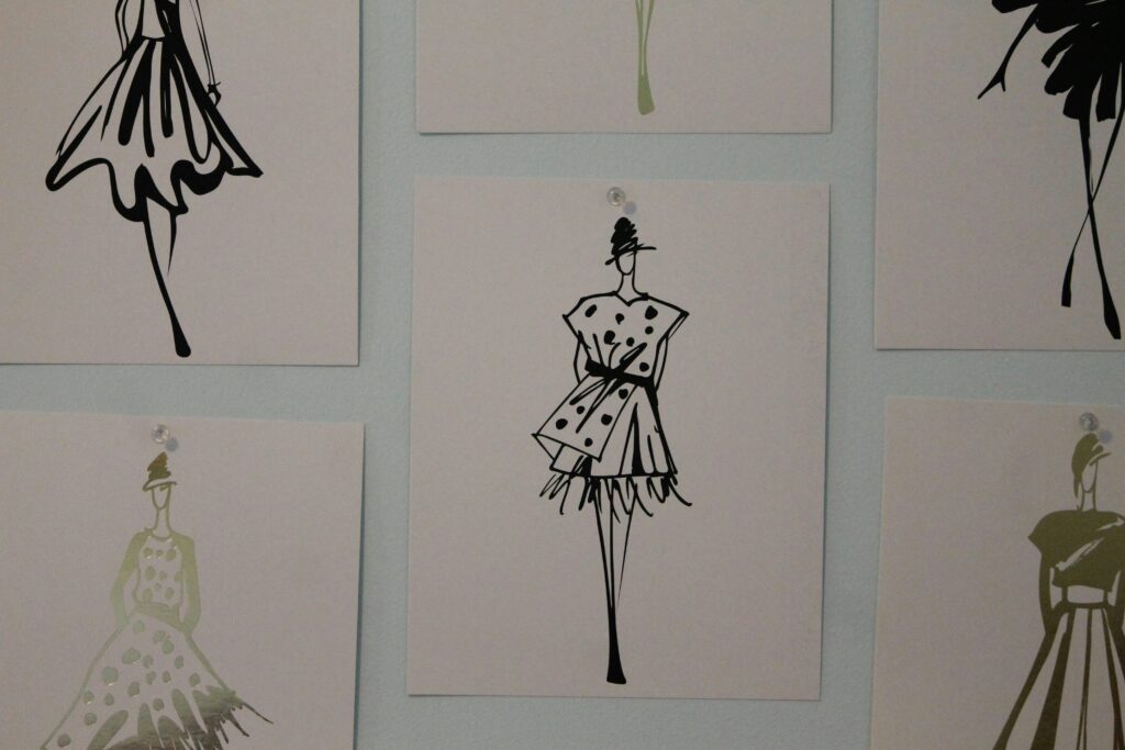 a fashion wall with outfit ideas drawn on multiple sheets on paper