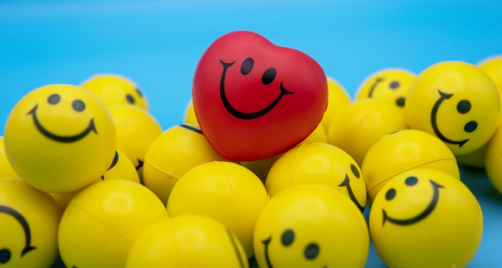 loads of smily rubber balls with one shaped like a red heart