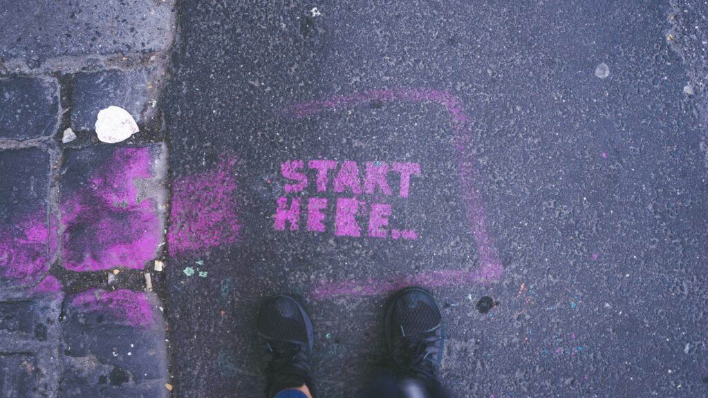  A road pavement with painted words reading "Start here..."