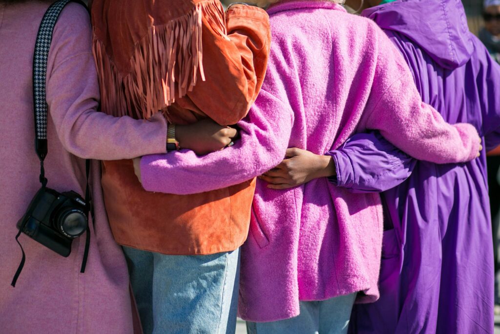 Women in vibrant cardigans hugging