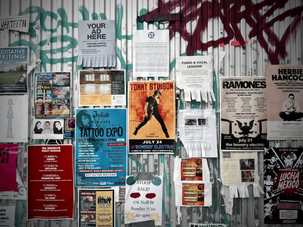 A wall with bunch of posters stuck 